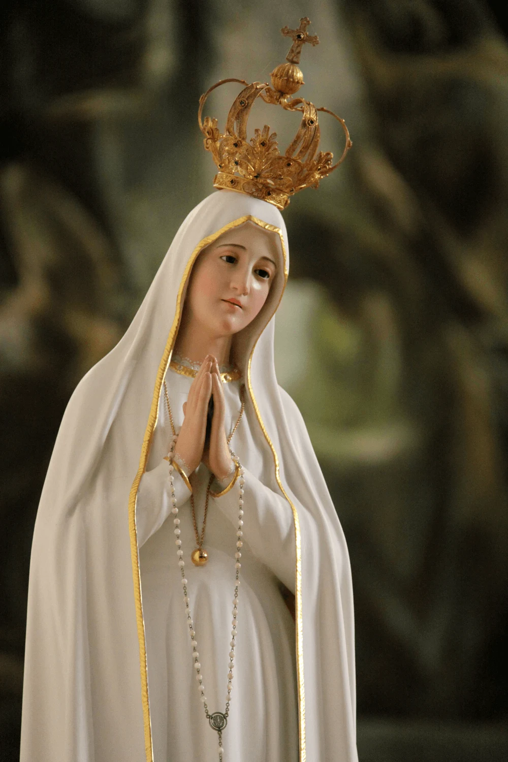 Gekrönte Statue der Muttergottes von Fatima mit gefalteten Händen im Gebet.